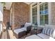 Cozy front porch seating area with wicker furniture, striped pillows, and decorative lanterns at 3225 Suffolk Dr, Cumming, GA 30041