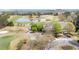 Aerial view of a golf course with a water hazard alongside a clubhouse with golf carts parked in front at 3225 Suffolk Dr, Cumming, GA 30041