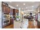 Open kitchen with white island and stainless steel oven connects to the dining and living area at 3225 Suffolk Dr, Cumming, GA 30041