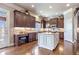 Well-lit kitchen features a white island, granite countertops, dark wood cabinets, and modern appliances at 3225 Suffolk Dr, Cumming, GA 30041