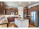 Spacious kitchen with stainless steel appliances, white island, granite countertops and dark wood cabinets at 3225 Suffolk Dr, Cumming, GA 30041