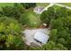 This aerial view showcases a large metal building and vast gravel parking area adjacent to wooded and grassy property at 1585 Elliott Rd, Mcdonough, GA 30252