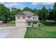 A two-story home boasts well-maintained landscaping, a spacious driveway, and a serene backdrop of mature trees at 1585 Elliott Rd, Mcdonough, GA 30252