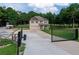 Two-story home featuring a manicured lawn, driveway, and gated entrance set against a lush backdrop of mature trees at 1585 Elliott Rd, Mcdonough, GA 30252