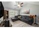 Comfortable living room with gray sectional sofa, ceiling fan, window, and modern decor at 1585 Elliott Rd, Mcdonough, GA 30252