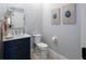 Stylish powder room featuring a navy vanity, stone countertop, and decorative wall art at 1585 Elliott Rd, Mcdonough, GA 30252
