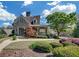 Exterior view of a stone house with a covered front porch and mature landscaping at 206 Glens Loop, Woodstock, GA 30188