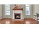 Living room with a brick fireplace, hardwood floors, and light-filled windows with a traditional mantel at 206 Glens Loop, Woodstock, GA 30188