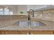 Kitchen sink featuring a granite countertop, neutral tile backsplash, and stainless steel faucet at 206 Glens Loop, Woodstock, GA 30188