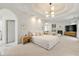 Large main bedroom featuring a fireplace, built-ins, tray ceiling, modern chandelier and neutral color palette at 1079 Arbor Ne Trce, Atlanta, GA 30319