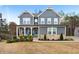 Charming two-story home featuring gray siding, a brick base, manicured landscaping and a welcoming front porch at 29 Laurelwood Nw Ln, Cartersville, GA 30121