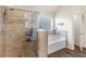 Bathroom with tiled shower and soaking tub, accented with neutral walls and a window at 346 M J Mccarthy Way, Hampton, GA 30228