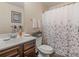 Cozy bathroom with a dark vanity, framed art, and a floral patterned shower curtain at 346 M J Mccarthy Way, Hampton, GA 30228