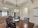 A bright dining room features wainscoting detail, coffered ceiling, an arched doorway, and decorative chandelier at 346 M J Mccarthy Way, Hampton, GA 30228