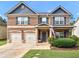 Inviting two-story brick home with a manicured lawn and a charming covered front porch at 346 M J Mccarthy Way, Hampton, GA 30228