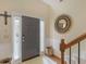 Foyer with a gray front door, decorative mirror, and wooden staircase at 346 M J Mccarthy Way, Hampton, GA 30228