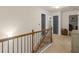 Open hallway with neutral carpet, wood and iron railing, and access to rooms with gray doors at 346 M J Mccarthy Way, Hampton, GA 30228