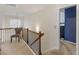 Hallway with neutral carpet, wood and iron railing, and a chair under a window at 346 M J Mccarthy Way, Hampton, GA 30228