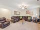 Living room with leather seating, media center, ceiling fan, and access to multiple areas of the home at 346 M J Mccarthy Way, Hampton, GA 30228