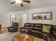 Large living room with leather seating, media center, ceiling fan, and access to multiple areas of the home at 346 M J Mccarthy Way, Hampton, GA 30228