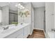 Bathroom featuring double sinks, a large mirror, wood look floors and glass enclosed shower at 6350 Lantana Village Way, Cumming, GA 30028