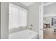Bright bathroom featuring a white tub with shower curtain, gray walls and a window at 6350 Lantana Village Way, Cumming, GA 30028