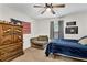 Bedroom with ceiling fan, wood armoire, chair, and decor at 6350 Lantana Village Way, Cumming, GA 30028