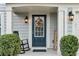 Inviting front entrance with a decorative wreath, a rocking chair, and manicured bushes at 6350 Lantana Village Way, Cumming, GA 30028
