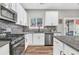 Modern kitchen features granite countertops, stainless steel appliances and a view to the backyard at 6350 Lantana Village Way, Cumming, GA 30028