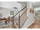 Elegant staircase with wood railings, carpeted steps, and views of the living and dining areas at 6350 Lantana Village Way, Cumming, GA 30028
