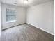 Bright bedroom with neutral carpet, large window, and freshly painted white walls at 7109 Gladstone Cir, Lithonia, GA 30038
