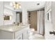 Well-lit bathroom featuring a spacious vanity with a white sink and shower with tile at 1025 Martins Lake Close, Roswell, GA 30076