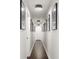 Long hallway with dark hardwood floors and artwork displayed along the white walls at 1025 Martins Lake Close, Roswell, GA 30076