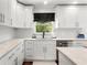 Well-lit kitchen with white cabinets, light countertops, stainless steel appliances, and a window view at 1025 Martins Lake Close, Roswell, GA 30076