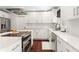 Modern kitchen with white cabinets, stainless steel appliances, light countertops, and hardwood floors at 1025 Martins Lake Close, Roswell, GA 30076