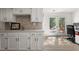 Bright kitchenette with white cabinets, stone backsplash, and access to the backyard at 1025 Martins Lake Close, Roswell, GA 30076
