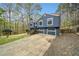 Front exterior view of two-story blue home featuring an attached garage, a well-kept lawn and manicured landscaping at 1303 Bass Dr, Woodstock, GA 30189