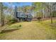 Exterior view of a blue two-story home with a well-manicured lawn and mature trees providing shade at 1303 Bass Dr, Woodstock, GA 30189