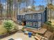 Back exterior of a two-story blue home featuring a deck, patio, and lush greenery, perfect for outdoor living at 1303 Bass Dr, Woodstock, GA 30189