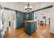 Bright kitchen featuring teal cabinetry, stainless steel refrigerator, a center island, and hardwood floors at 1303 Bass Dr, Woodstock, GA 30189