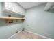 Clean, empty laundry room with tiled flooring and shelving above at 1303 Bass Dr, Woodstock, GA 30189