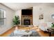 Bright living room featuring hardwood floors, a stone fireplace, and large windows at 1303 Bass Dr, Woodstock, GA 30189