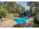 Backyard pool with a concrete surround, lounge seating and privacy fence with mature trees at 1303 Bass Dr, Woodstock, GA 30189