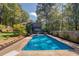 The backyard features a sparkling swimming pool with a concrete deck and privacy fence at 1303 Bass Dr, Woodstock, GA 30189