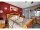 Bedroom featuring a large bed, red accent wall, and neutral carpeting at 170 Cobblestone Ct, Douglasville, GA 30134