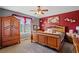 Spacious bedroom with a ceiling fan, a large bed, and a big wooden dresser at 170 Cobblestone Ct, Douglasville, GA 30134