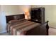 Bedroom with cozy brown and red bedding and a wooden sleigh bed frame, next to a modern storage wardrobe at 3259 S Pointe Ct, Atlanta, GA 30340
