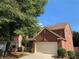 Charming two-story brick home with an attached two-car garage and mature landscaping in a suburban neighborhood at 3259 S Pointe Ct, Atlanta, GA 30340