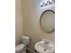 A simple powder room features a pedestal sink with an oval mirror and a standard toilet in a neutral color scheme at 3259 S Pointe Ct, Atlanta, GA 30340