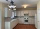 Well-lit kitchen features white cabinets, a tile backsplash, wooden floor and modern appliances at 3259 S Pointe Ct, Atlanta, GA 30340